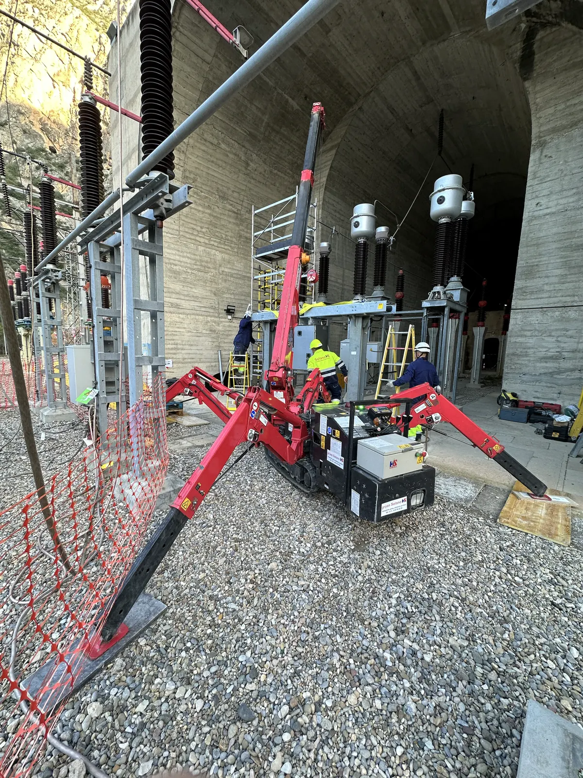 Mini grúa sobre orugas y el equipo de Solano trabajando dentro de una subestación eléctrica