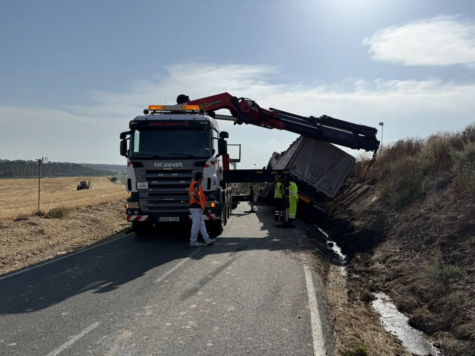 Grúa de asistencia trabajando en cuneta de carretera