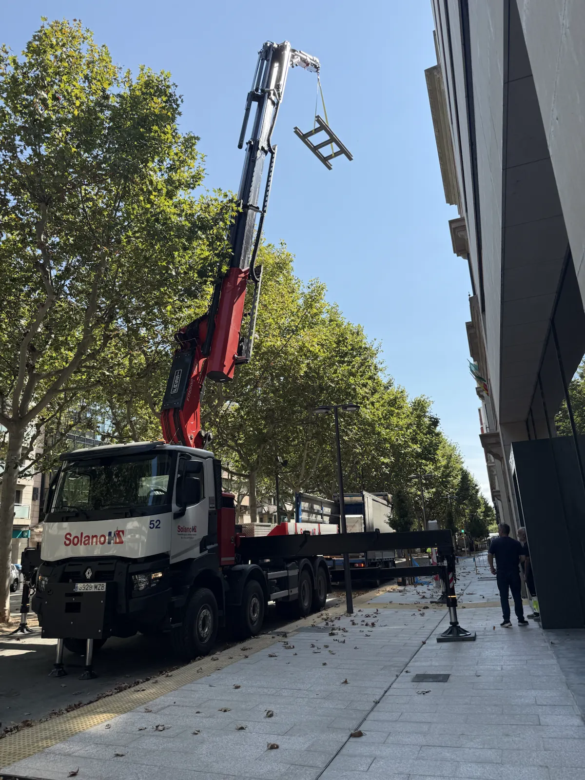 Camión grúa estabilizado trabajando en calle urbana